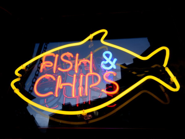 Striking yellow & orange neon sign for a fish and chips shop in Brighton